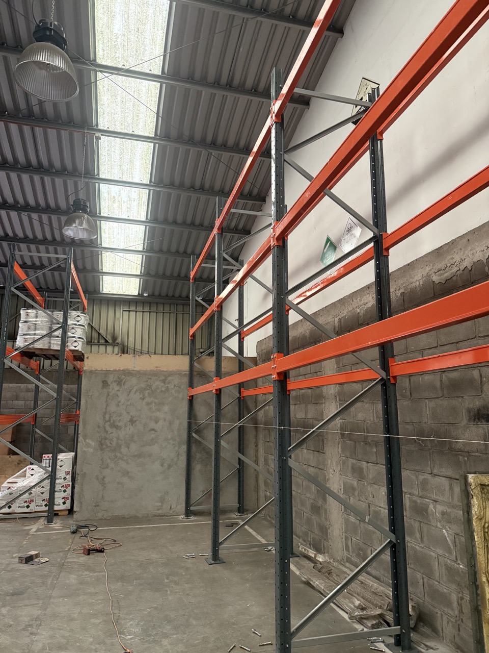Rack selectivo montado en bodega industrial en Quilicura, con vigas naranjas y marcos grises