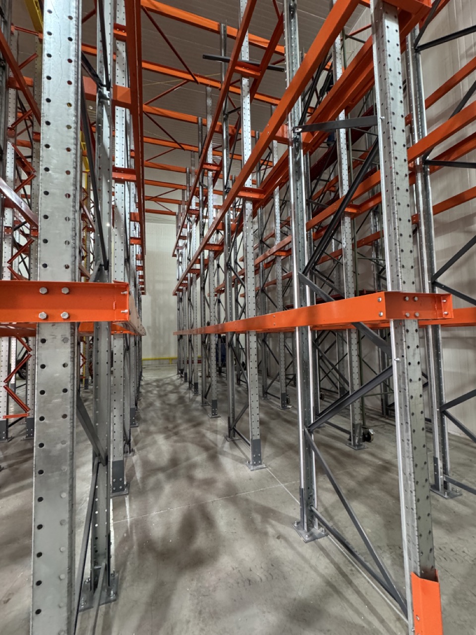 Pasillo interior del sistema Drive In con estructura galvanizada y brazos naranjos