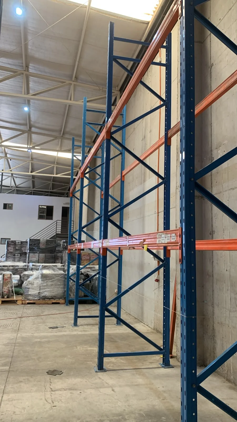 Detalle de rack selectivo con vigas naranjas en bodega de alimentos en Quilicura